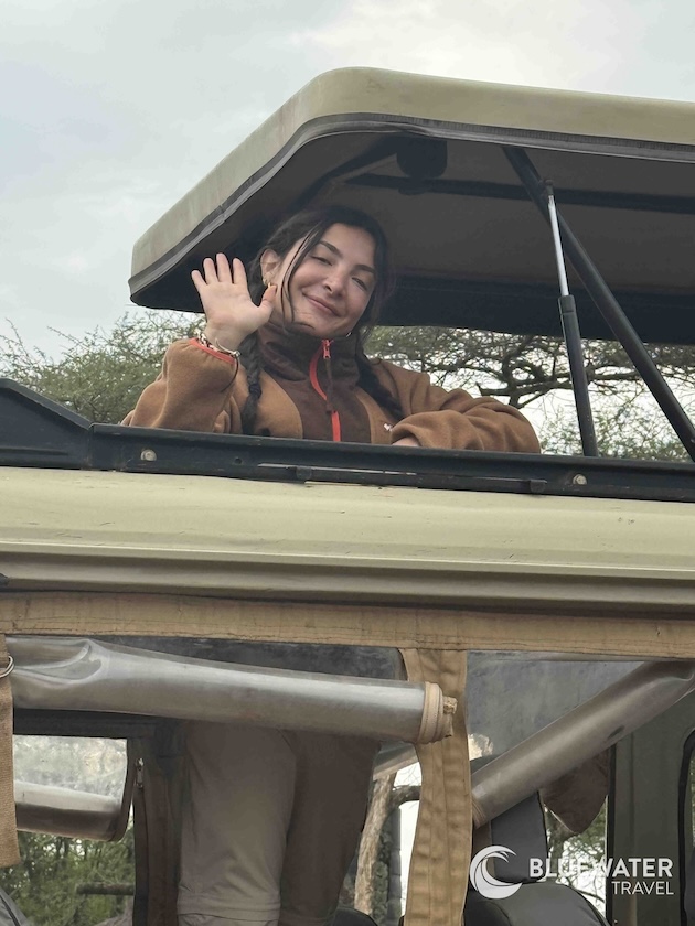 A guest waves at the camera